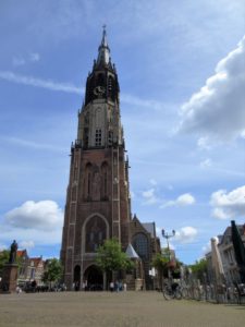 A tall church on one side of a large public square.